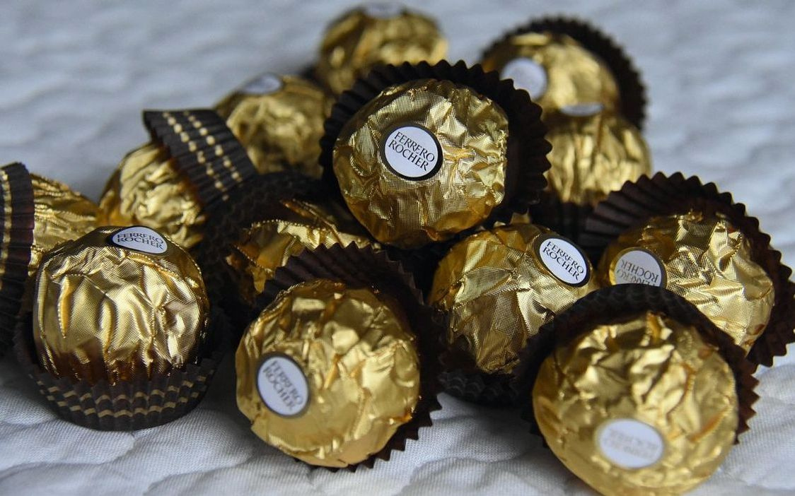 Una caja de chocolate con variedad de caramelos y chupetines
